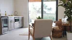A modern kitchen with a dining area, large windows, and a potted plant. - Hidden Hacienda King Room with Garden View (Temecula)