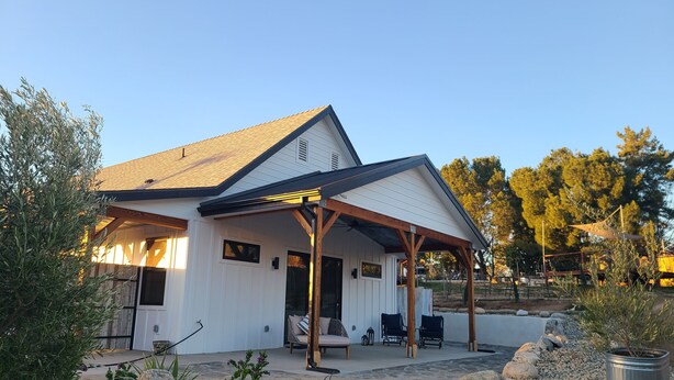 A house with a covered patio, outdoor seating, and a garden with rocks and plants. - Hidden Hacienda King Room with Garden View (Temecula)