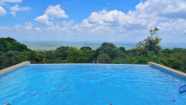 A swimming pool with a view of the ocean and surrounding greenery. - Mara Engai Wilderness Lodge (Nairobi)