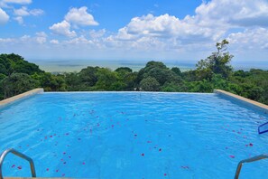 A swimming pool with a view of the ocean and surrounding greenery. - Mara Engai Wilderness Lodge (Nairobi)