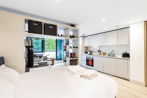 1 habitación, escritorio y tabla de planchar con plancha