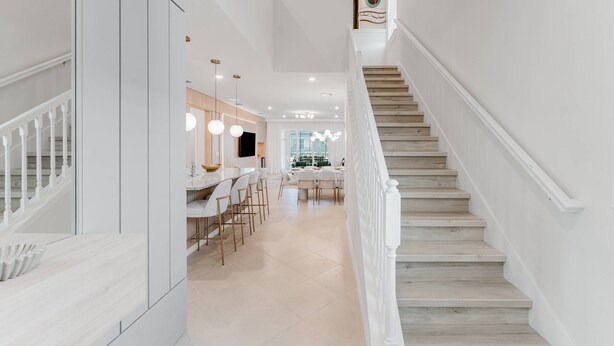 Ein modernes Interieur mit Treppe, Essbereich und Küche.