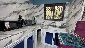 Una cucina compatta con forno a microonde, fornello e lavello.