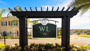 A sign for West Lucaya Village Resort with a pergola structure.