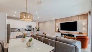 Una cocina moderna con armarios blancos, microondas y cafetera.