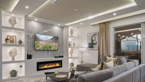 A modern living room with a fireplace, a flat-screen TV, and a sofa set. - Last Minute Disney Getaway! Private Pool & Themed Bedrooms. Book Now! #136701 (Orlando)