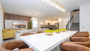 A modern kitchen with white cabinets, stainless steel appliances, and a large island with stools.