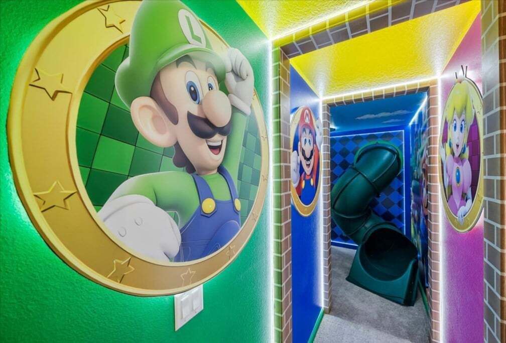 A children's play area with Mario-themed decorations, including a large circular mural and a slide.