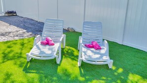 Two white lawn chairs with pink towels placed on a well-maintained lawn. - Tropical Paradise in Largo (Largo)
