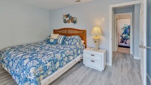 Ein Schlafzimmer mit Bett, Nachttisch und Deckenventilator.