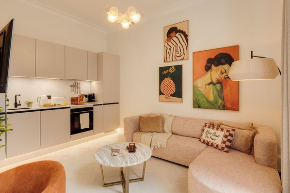 Ein modernes Wohnzimmer mit einer Couch, einem Couchtisch und einer Küche im Hintergrund.