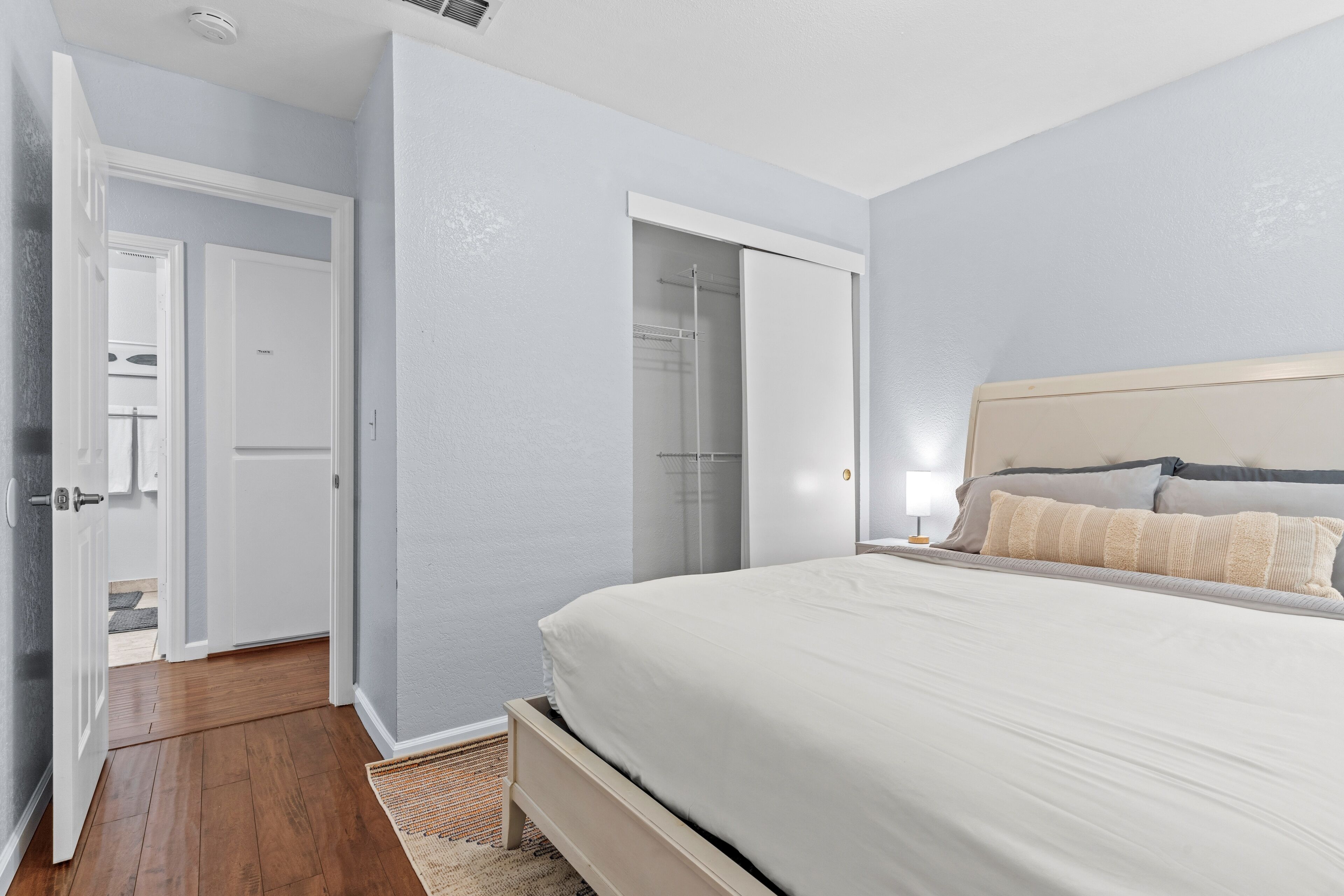 A bedroom with a bed, a wardrobe, and a walk-in closet.