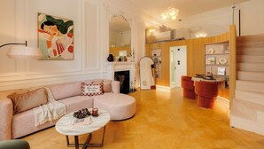 Un salon spacieux avec un canapé incurvé, une table basse ronde et une cheminée.