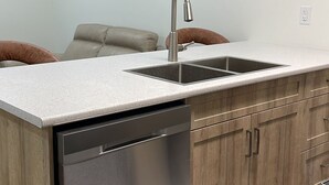 Una cocina moderna con lavavajillas, un lavabo y armarios de madera.