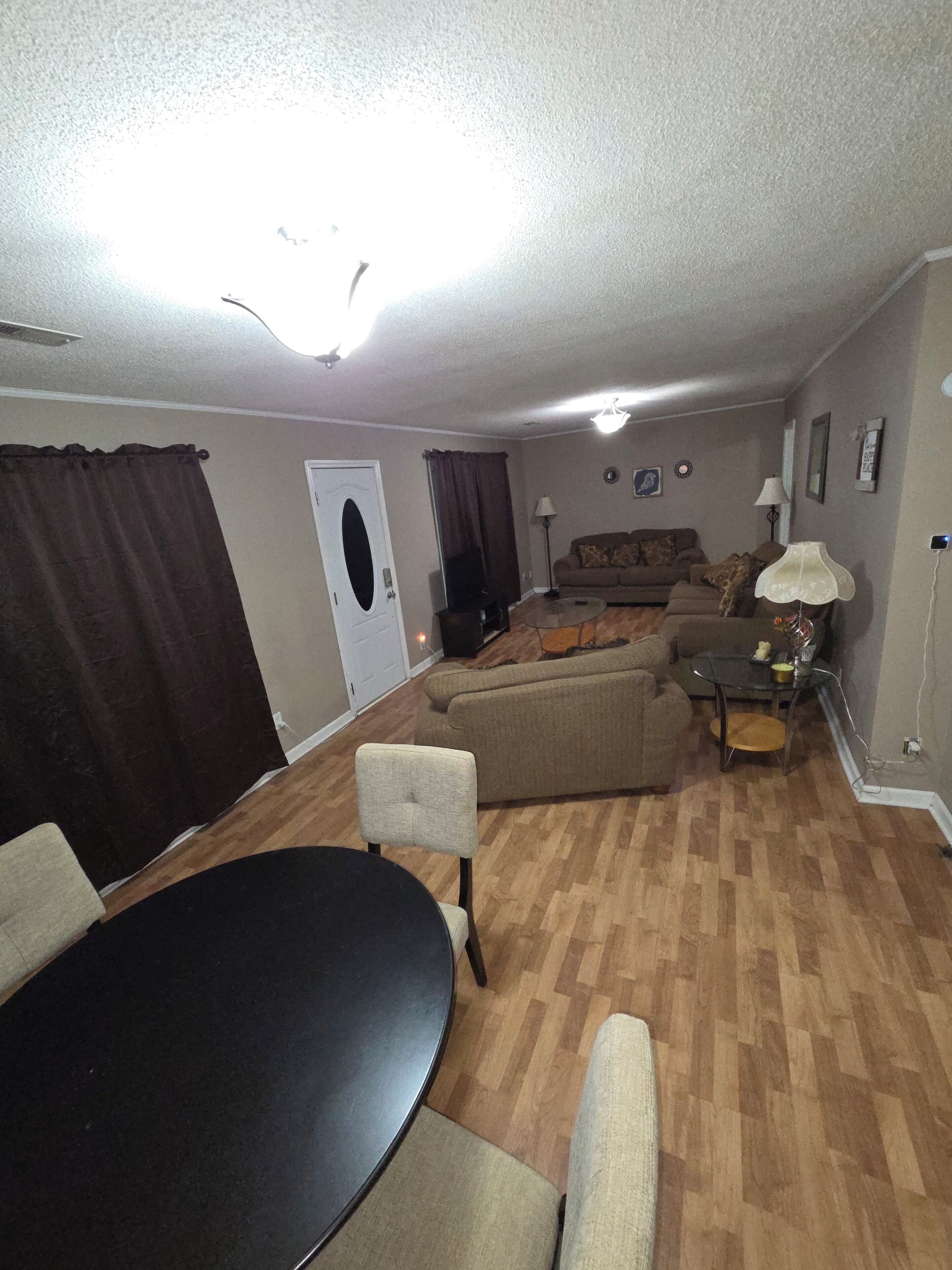 Una sala de estar con una mesa redonda, dos sofás, una mesa baja y un televisor.