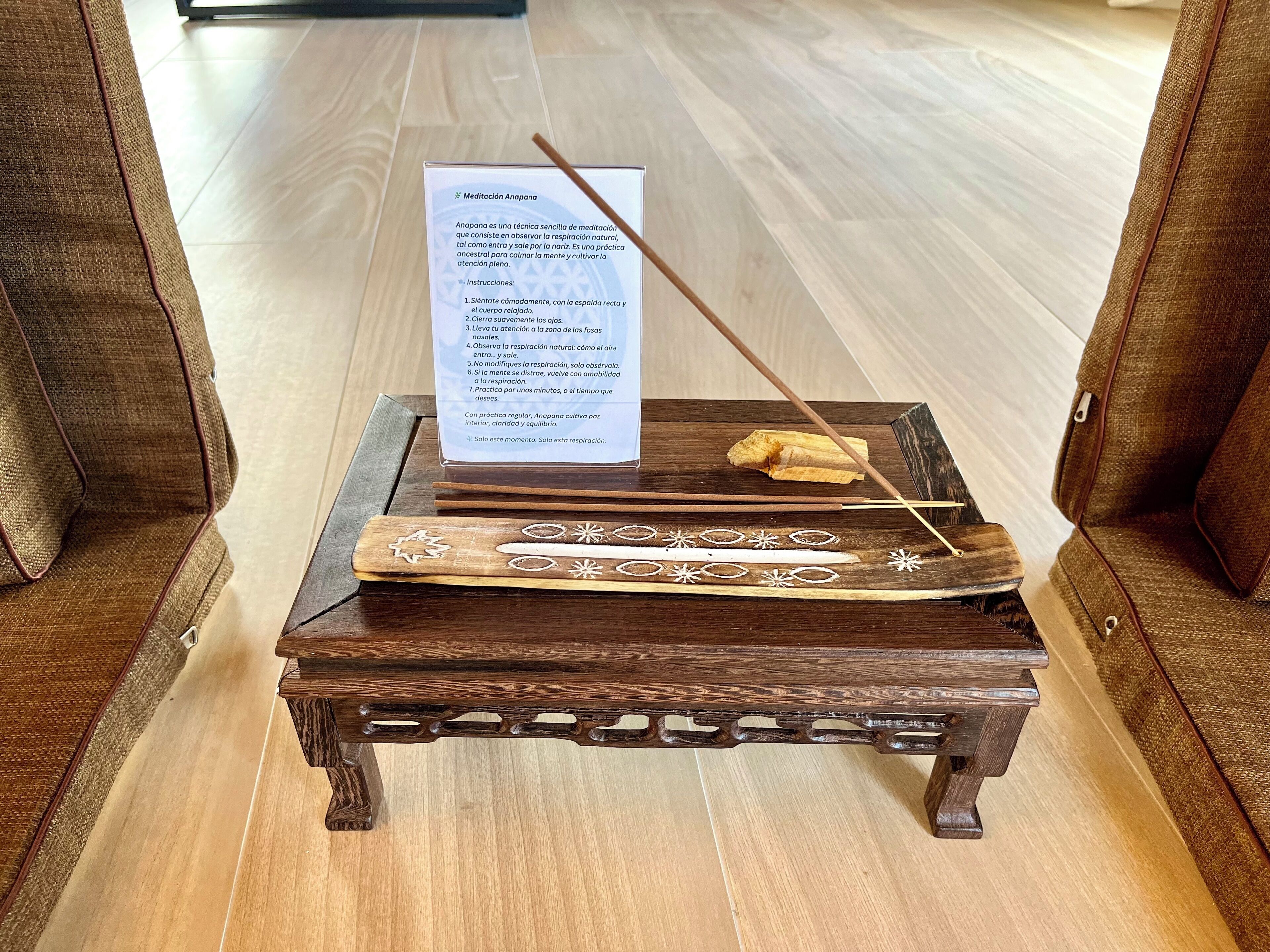 Un tapis de méditation avec un mode d’emploi, posé sur une table en bois.
