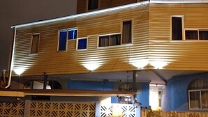 Un edificio de dos pisos con techo plano y varias ventanas.