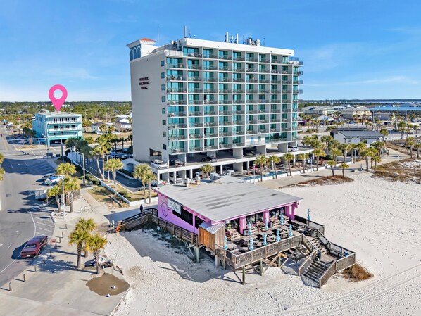 A multi-story hotel with a modern design, featuring balconies and large windows.