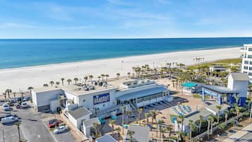 A coastal hotel with a beach view, parking, and a sign reading "The Hangout".