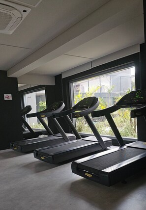 A gym with treadmills, a large window, and a ceiling vent. - Condominio Helbor B.liv (São Paulo)