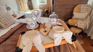 A cozy room with a wooden table set for tea, a plush sofa, and a brick wall. - A Quiet Corner in the Serra Gaúcha (Picada Café)