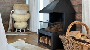 A cozy living room with a fireplace, a television, and a comfortable chair. - A Quiet Corner in the Serra Gaúcha (Picada Café)