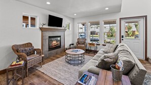 A living room with a fireplace, wicker furniture, a sofa, and a television. - The Bear's Den - Dover ID (Dover)