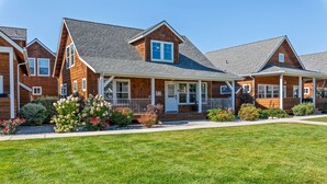 A row of wooden houses with a covered porch and a well-maintained lawn. - The Bear's Den - Dover ID (Dover)