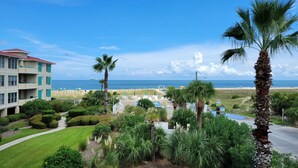 A resort with a pool, palm trees, and a view of the beach and ocean. - Desoto Beach Club 2 Tybee Vacation Rentals (Tybee Island)