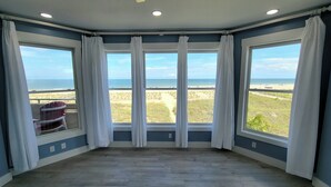 A room with a large bay window overlooking a beach. - Desoto Beach Club 2 Tybee Vacation Rentals (Tybee Island)
