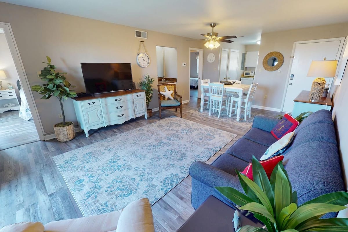 A living room with a sofa, TV, and dining area.