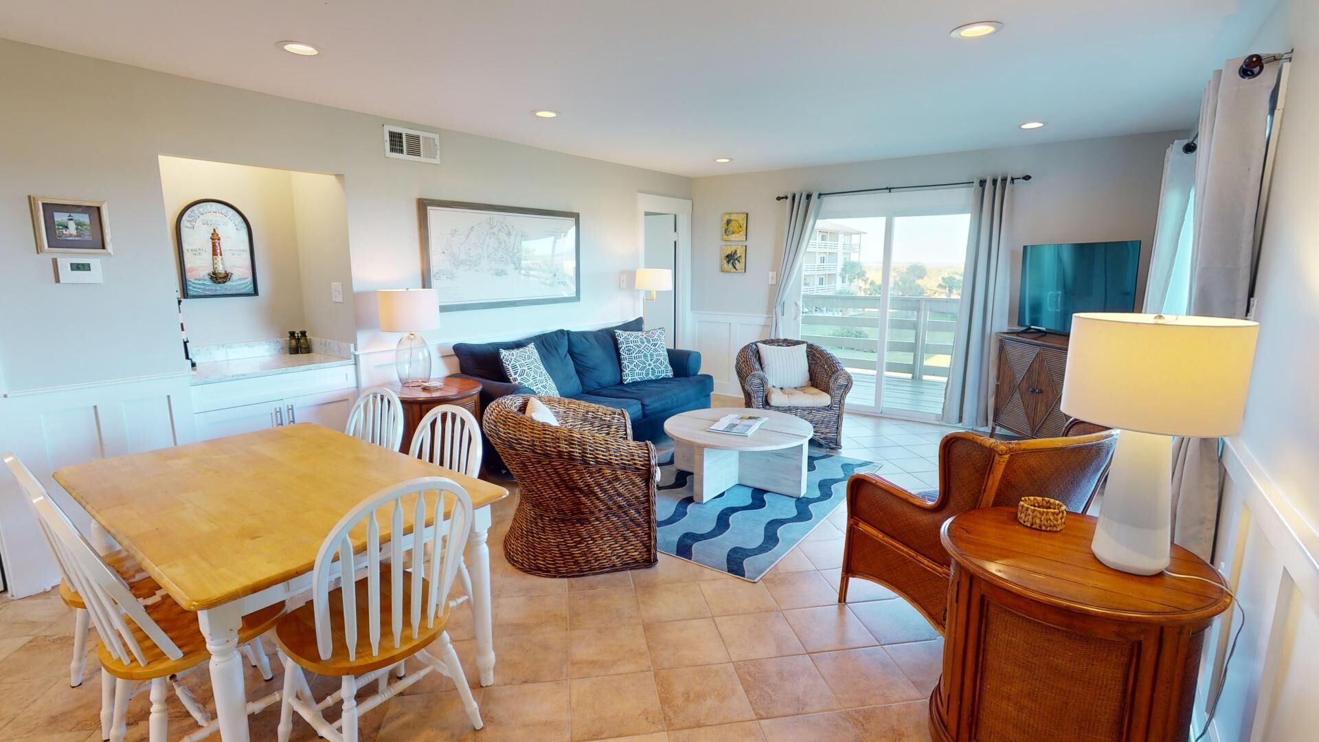 A well-lit living room with a dining area, a sofa set, and a TV.