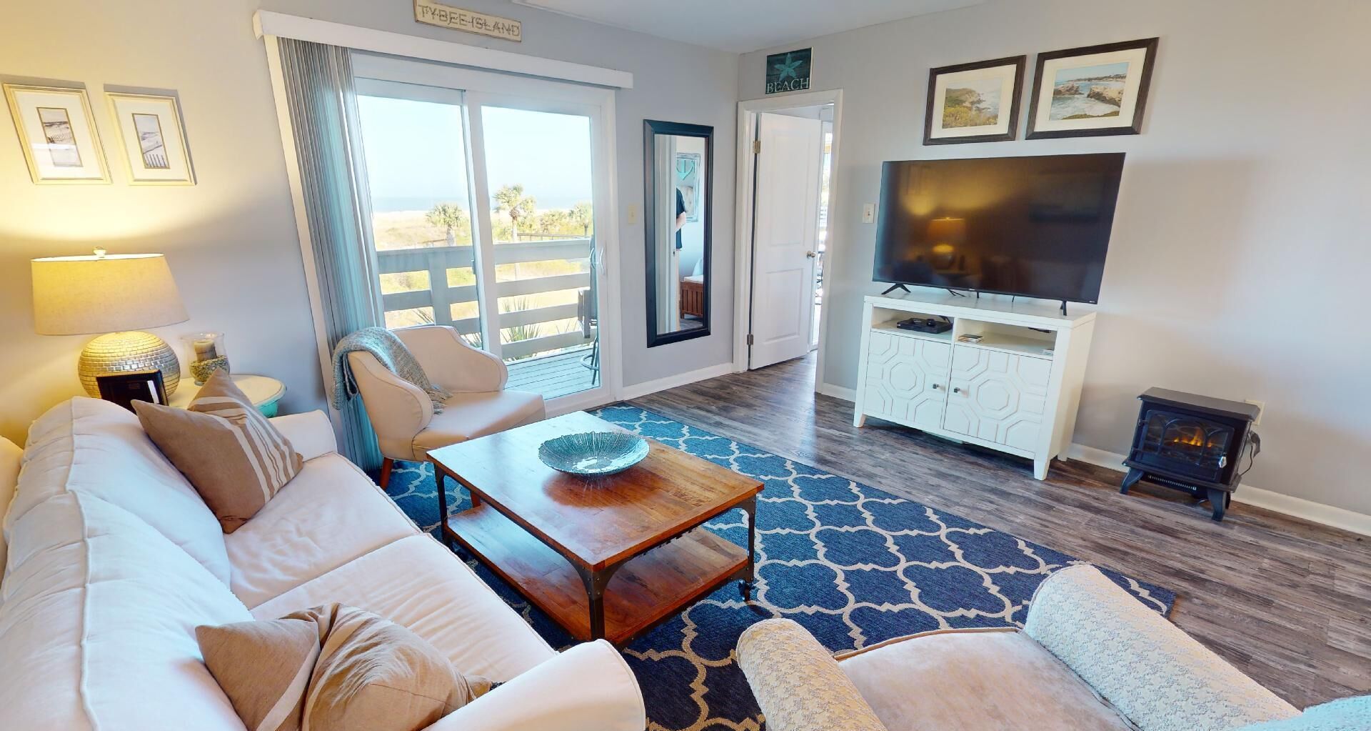 A living room with a sofa, armchairs, a coffee table, a TV, and a fireplace.