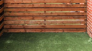 A courtyard with wooden benches, a brick building, and a green lawn. - Student Only Tatton House  (Manchester)