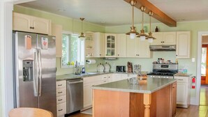 A spacious kitchen with wooden beams, a large island, and a dining area with a wooden table and chairs. - Minutes from SLU, Clarkson, & SUNY schools.  4-bd Family Friendly Farmhouse (Canton)