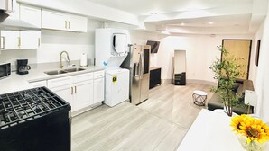 A modern kitchen with white cabinets, a built-in microwave, a coffee maker, and a refrigerator. - Charming Glass-Front One Bedroom Spacious Living Free Parking (Los Angeles)