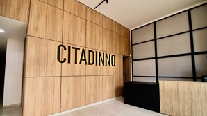 A reception area with a wooden wall displaying the name "CITADINNO". - Downtown Bogotá | Work & Stay (Bogotá)