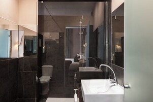 Un baño moderno con inodoro, bidé y un lavabo amplio.