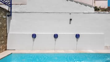 Una piscina con pared blanca y detalles azules.
