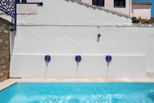 Una piscina con pared blanca y detalles azules.