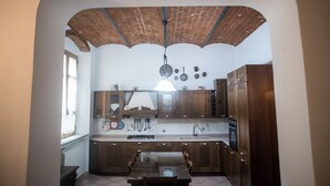 A kitchen with a brick ceiling, wooden cabinets, a central island, and a hanging light fixture.