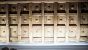 A wooden wall with evenly spaced circular cutouts, likely part of a building's interior design.