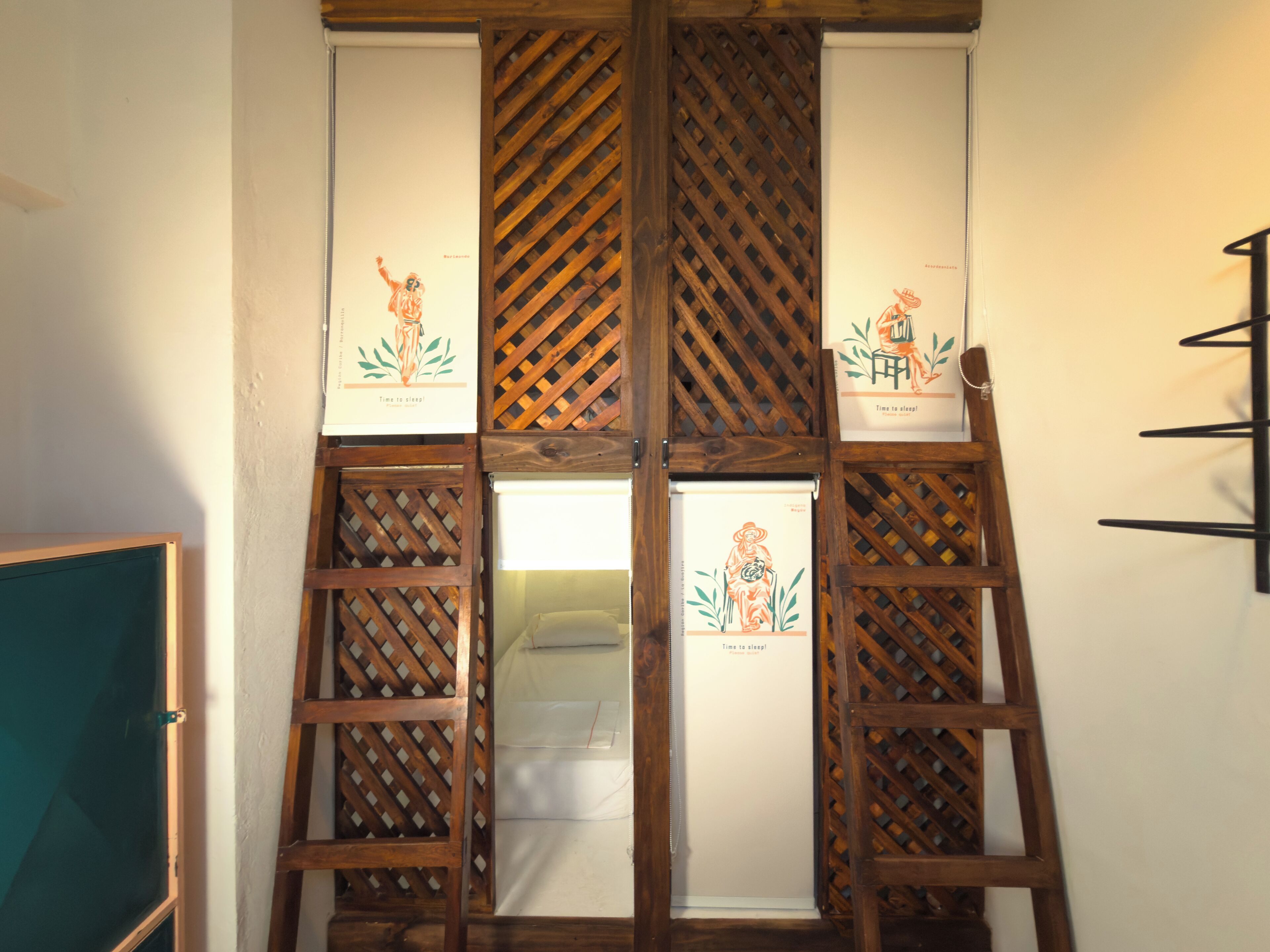 A room with a wooden lattice partition, a bed with a white mattress, and a wall-mounted shelf.