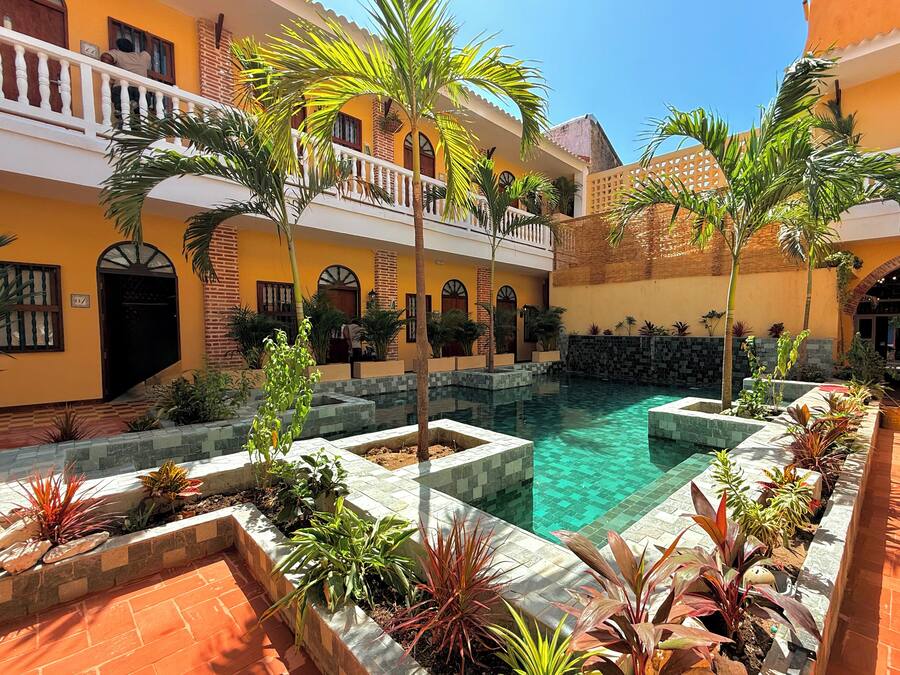 A courtyard with a pool, surrounded by buildings with balconies and arched windows.