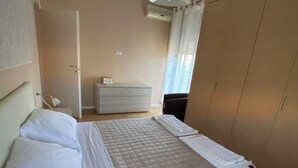 A bedroom with a bed, a bedside table, a wardrobe, and a ceiling light. - Apartment near american school from the center of milan from IEO and Humanitas (Noverasco)
