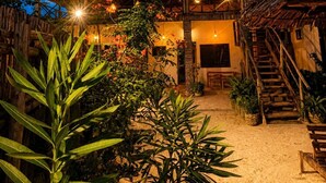 A thatched-roof structure with string lights, a staircase, and tropical plants. - Zanzibar beach escape  (Bwejuu)