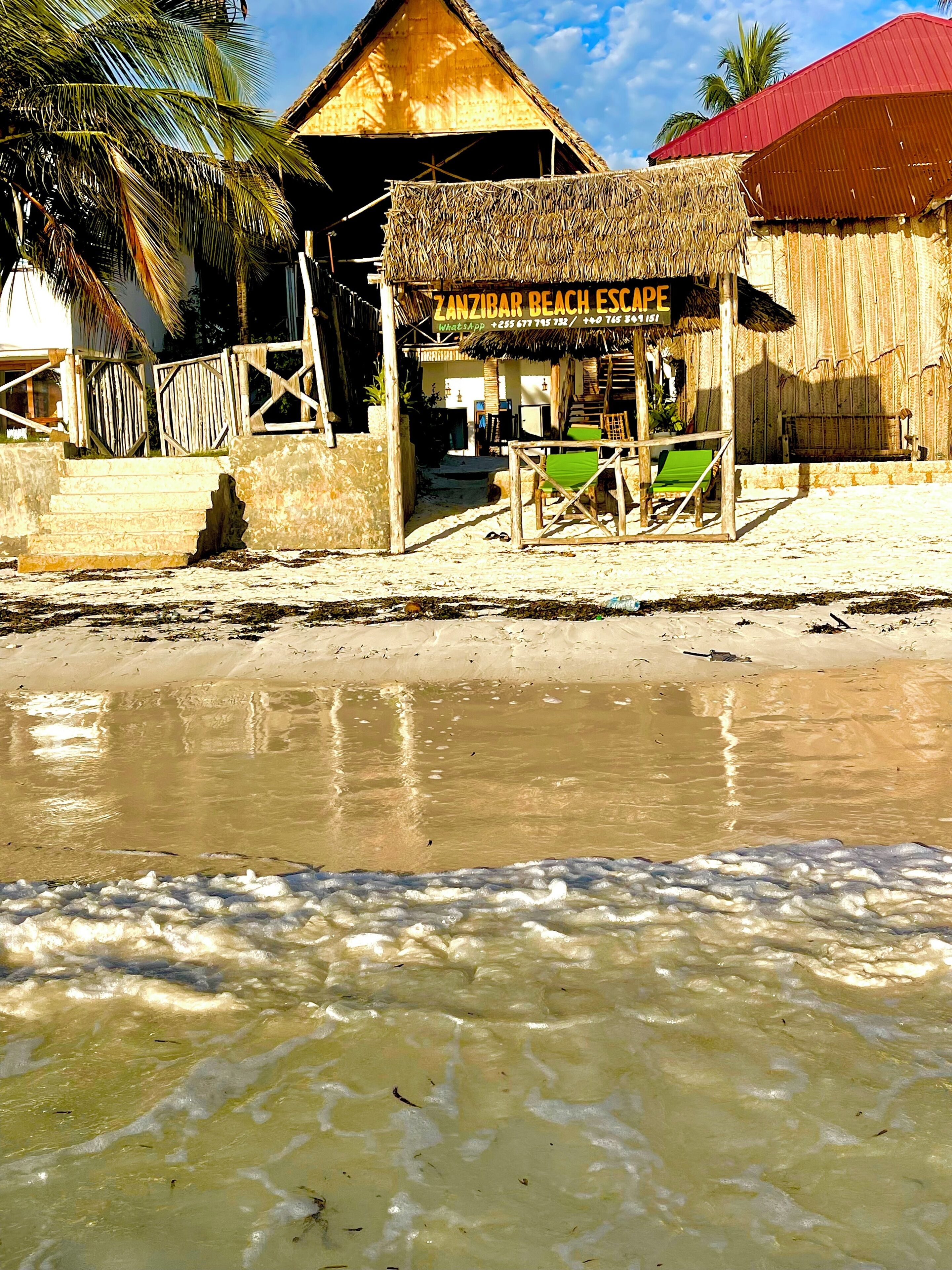 Una estructura frente a la playa con un cartel que dice 'Zanzibar Beach Escape'.