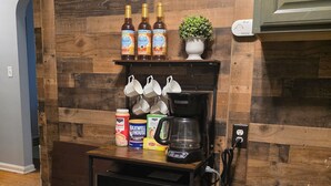 A kitchen with a wooden wall, a coffee maker, a microwave, and various kitchen items on a shelf. - Charming Cape Cod minutes from YSU, Covelli Center and many more! Pet Friendly (Youngstown)