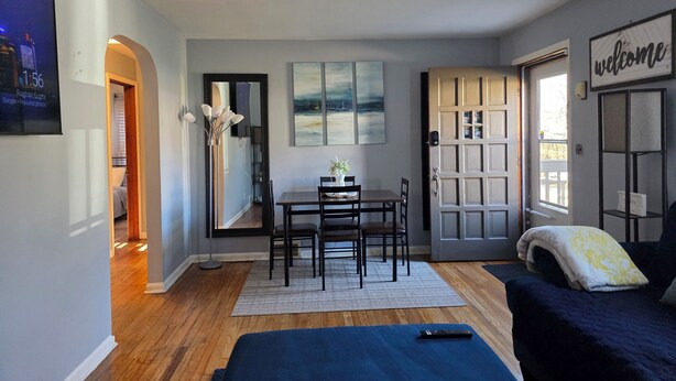 A modern, well-lit room with a dining area, a bed, and a 'welcome' sign. - Charming Cape Cod minutes from YSU, Covelli Center and many more! Pet Friendly (Youngstown)