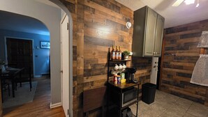 A kitchen with wooden walls, a coffee machine, and a microwave on a shelf. - Charming Cape Cod minutes from YSU, Covelli Center and many more! Pet Friendly (Youngstown)